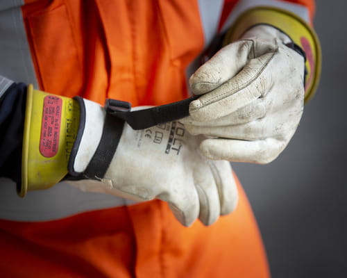 Contractor wearing health and safety overalls and gloves. 