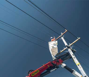 contractor in bucket truck working on a power pole