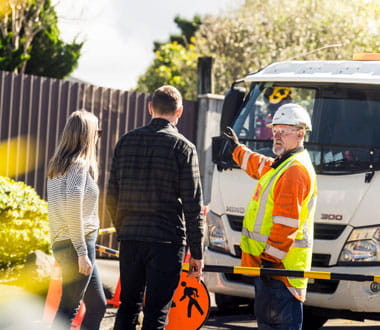 people standing outside in front of house talking to contractor