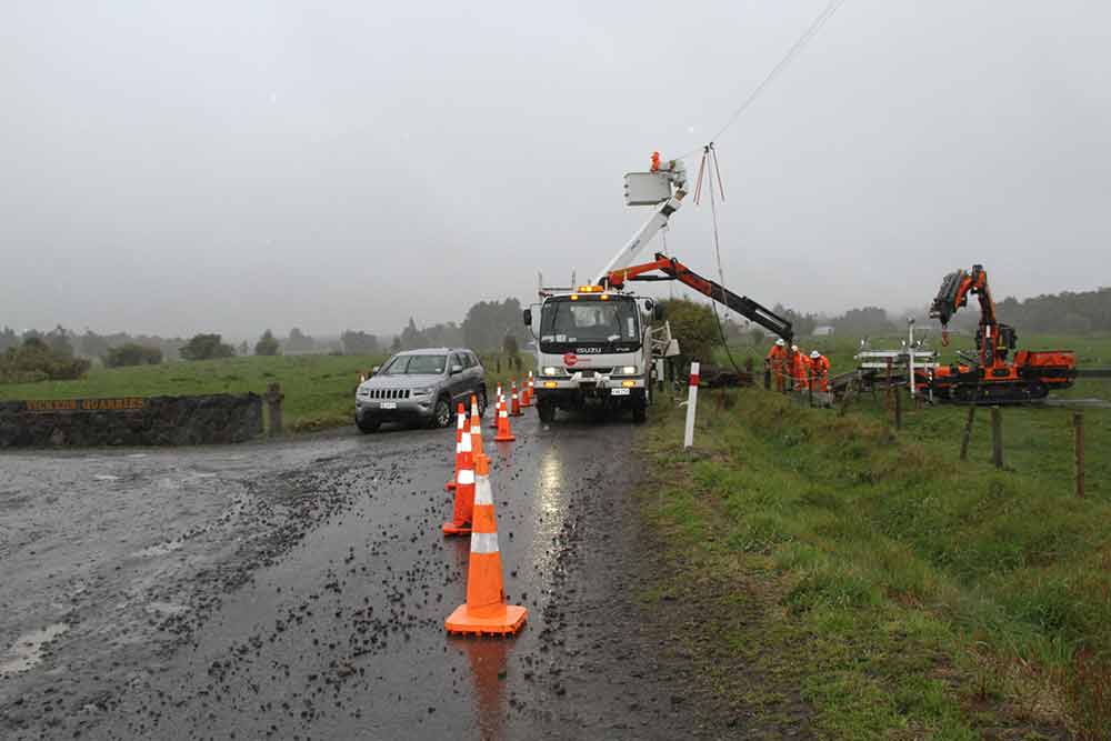 Crew working on overhead lines in the rain.