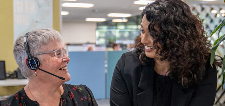 Two women talking at desk
