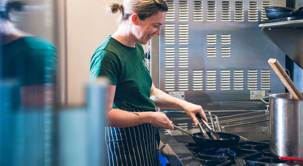 woman cooking on a gas cook top