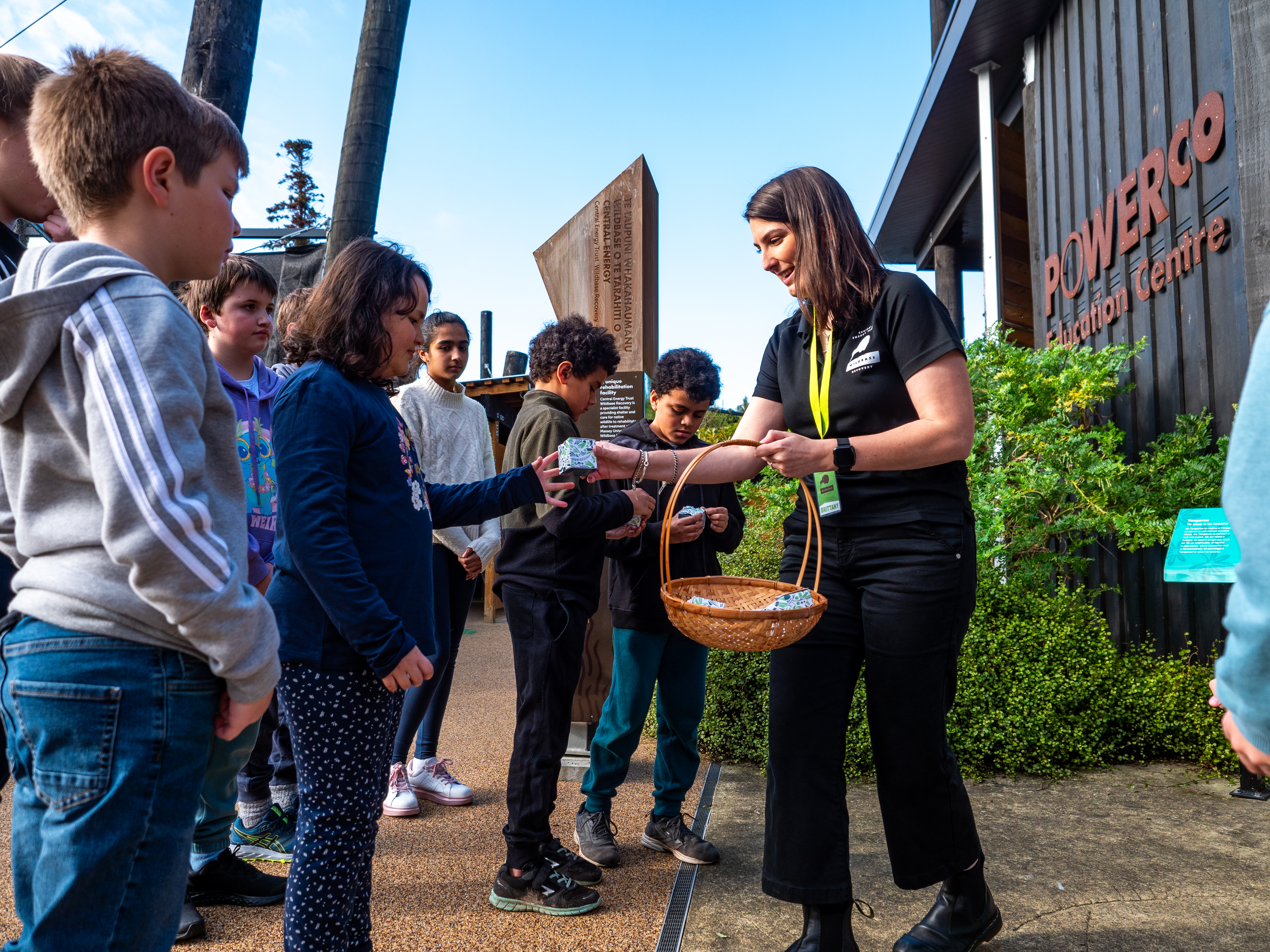 Wildbase Recovery Centre team member handing out Replant for Tomorrow seed packets to students