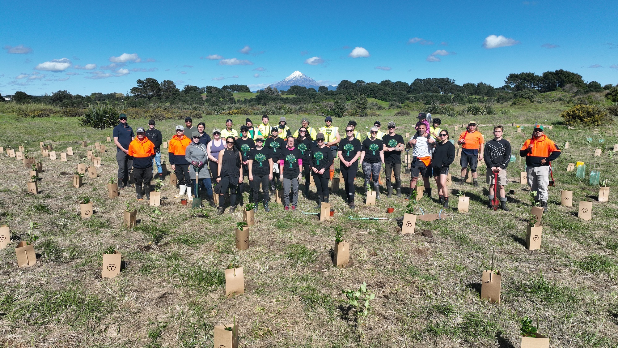 A group of volunteers planting trees on a piece of land at the mouth of New Plymouth's Waiwhakaiho River.