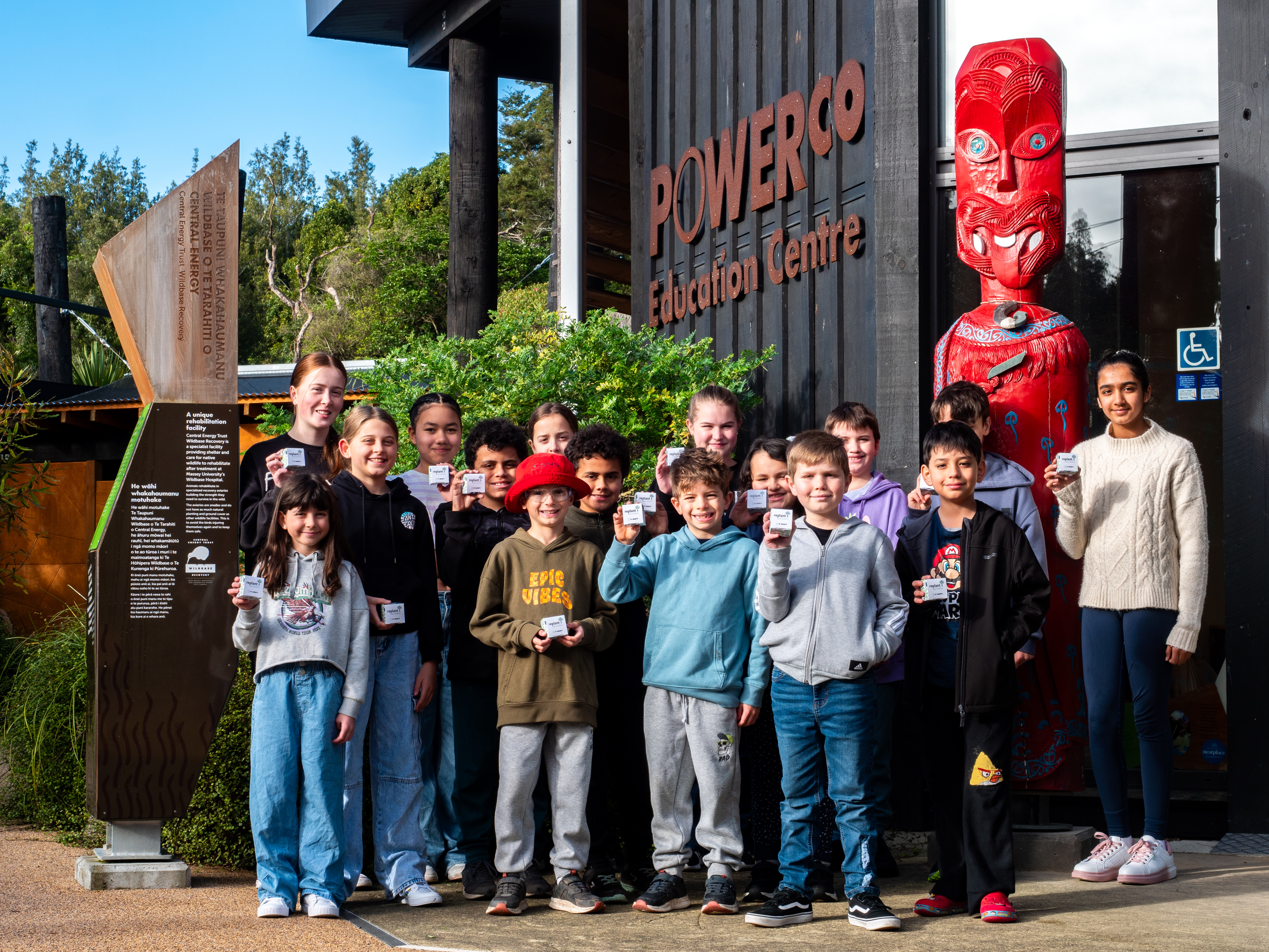 Students holding their Replant for Tomorrow seed packets outside the Powerco Education Centre