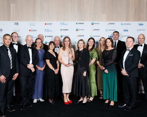 A group of people dressed up in evening wear with one woman holding a trophy.