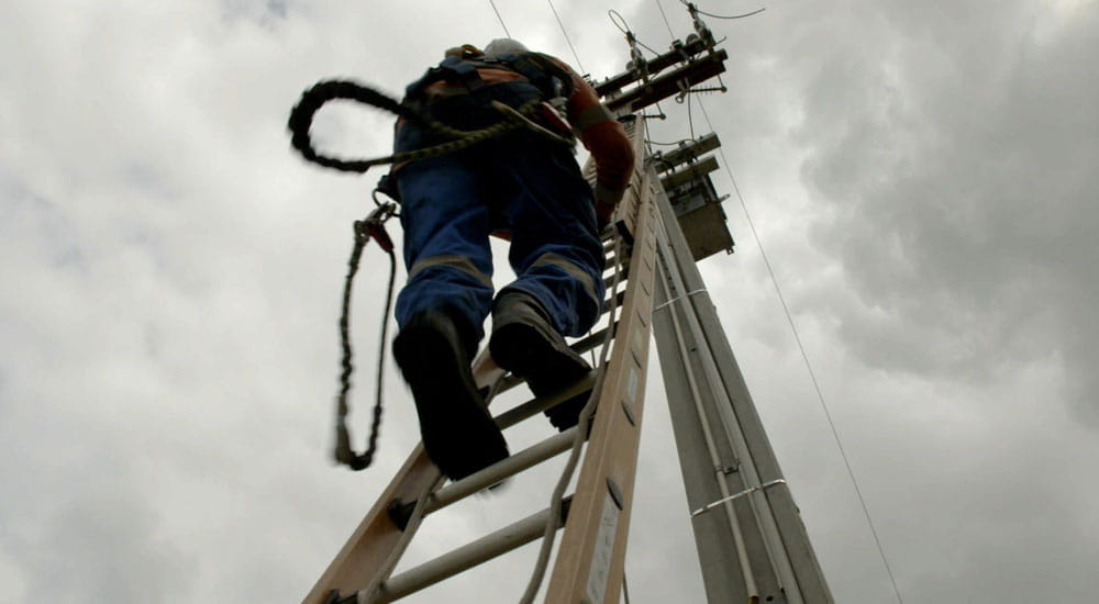person climbing power pole