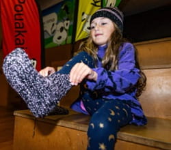 Girl with knitted slipper. 