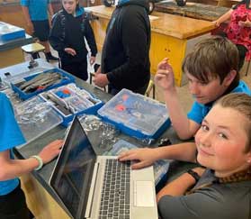 Children using laptop and science equipment