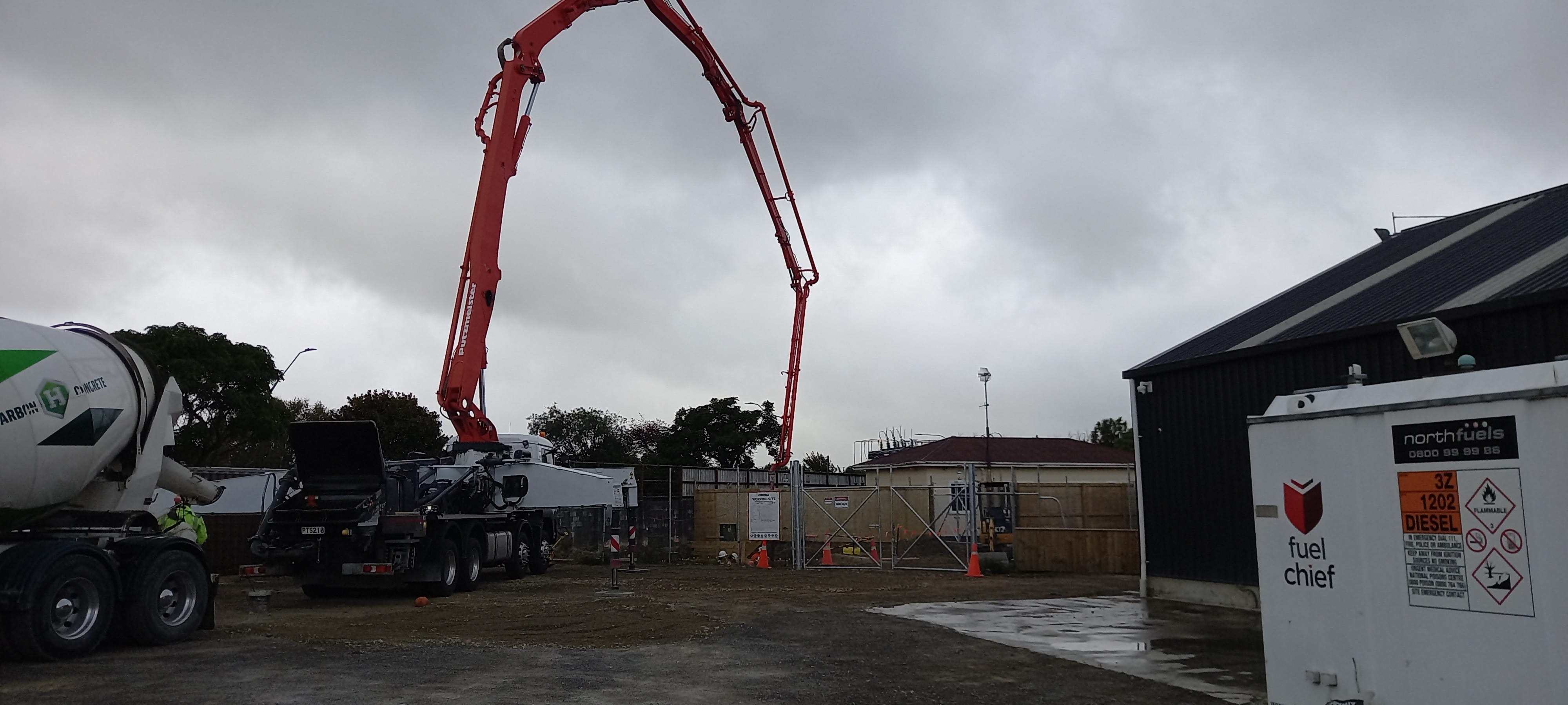 A concrete truck pouring concrete from a long pipe